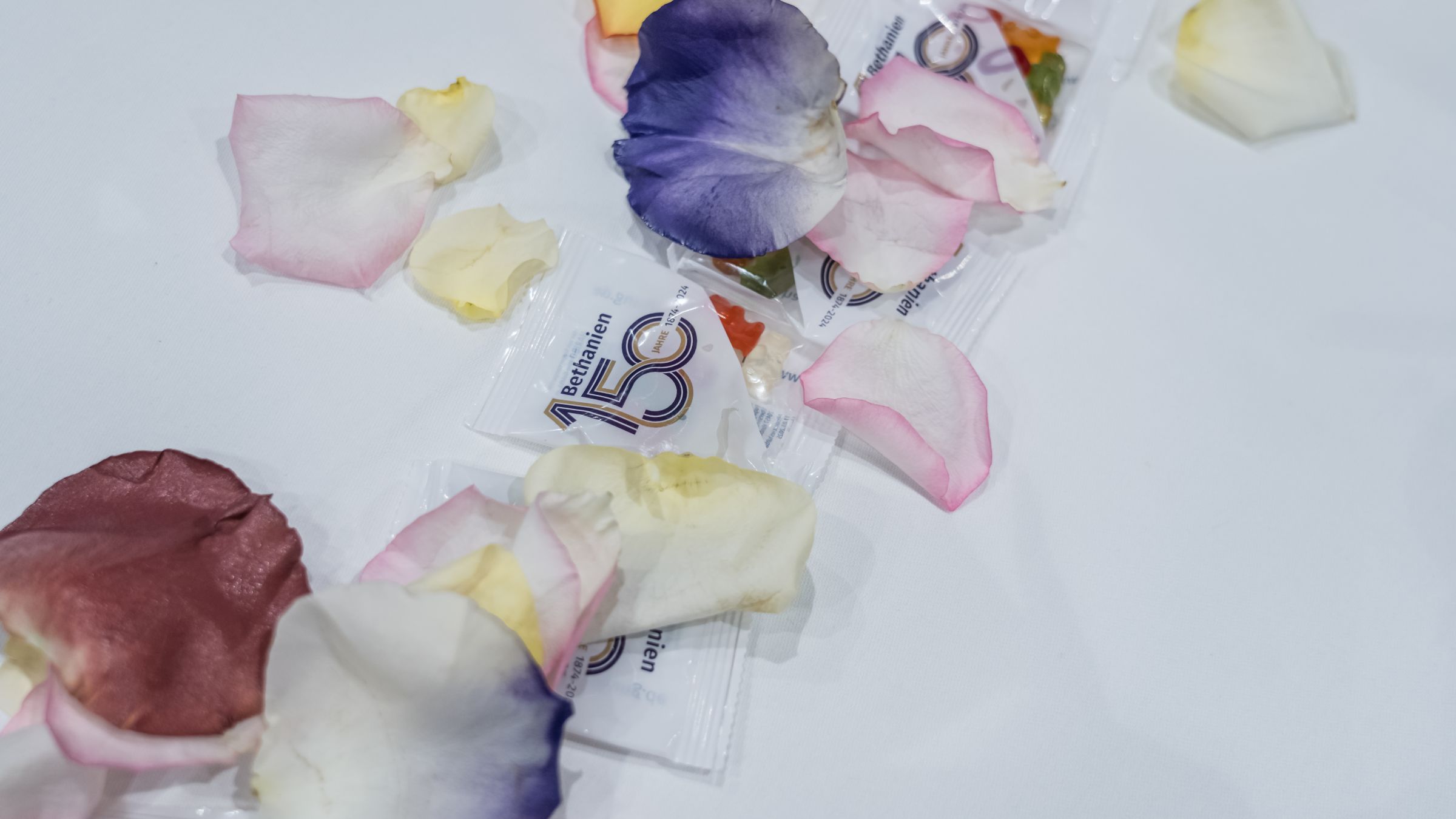 Tischdeko mit Blumenblättern und Gummibärchen