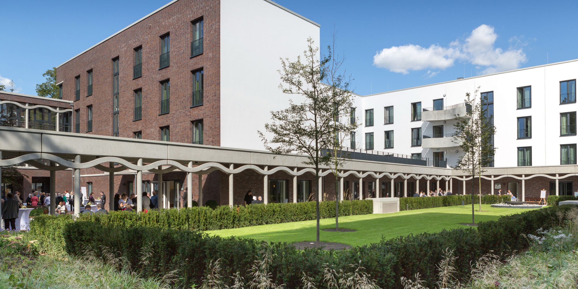 ein modernes Gebäude mit einem parkähnlichen Innenhof