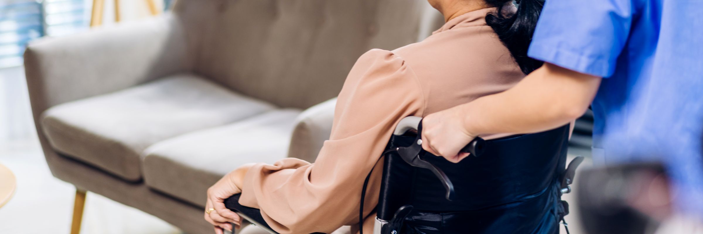 Nahaufnahme eines Rollstuhls mit Person von hinten