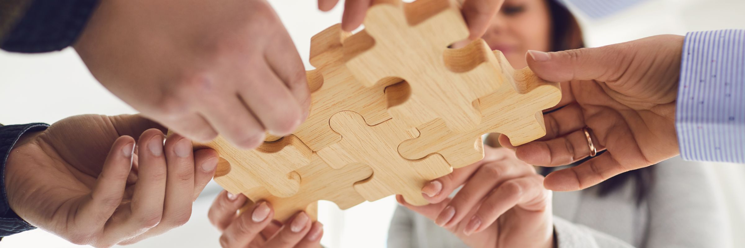 Menschen halten Puzzle Teile zusammen