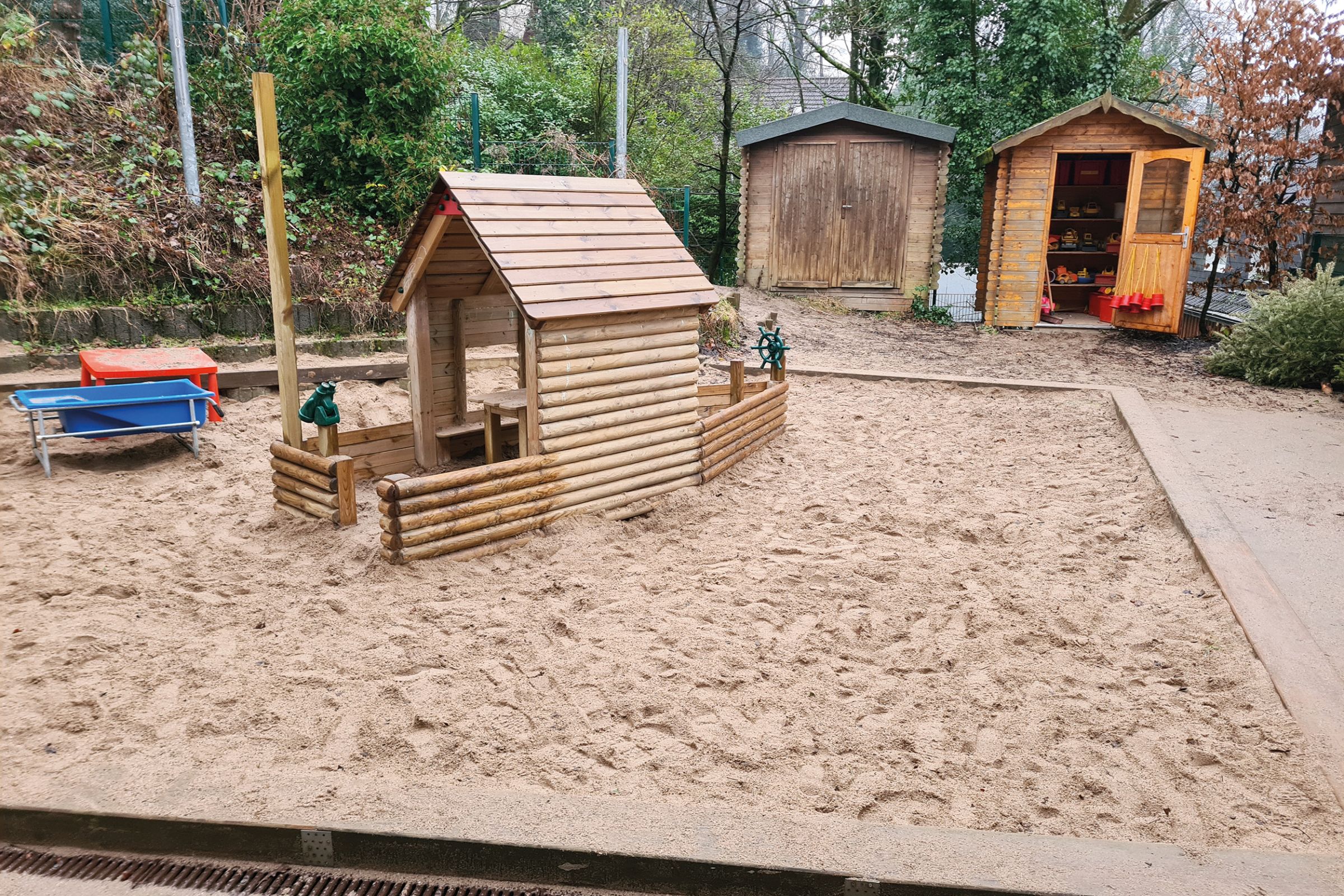 Ein Spielhaus mit Sandkasten auf dem Außengelände der Bethesda-Kita in Wuppertal .