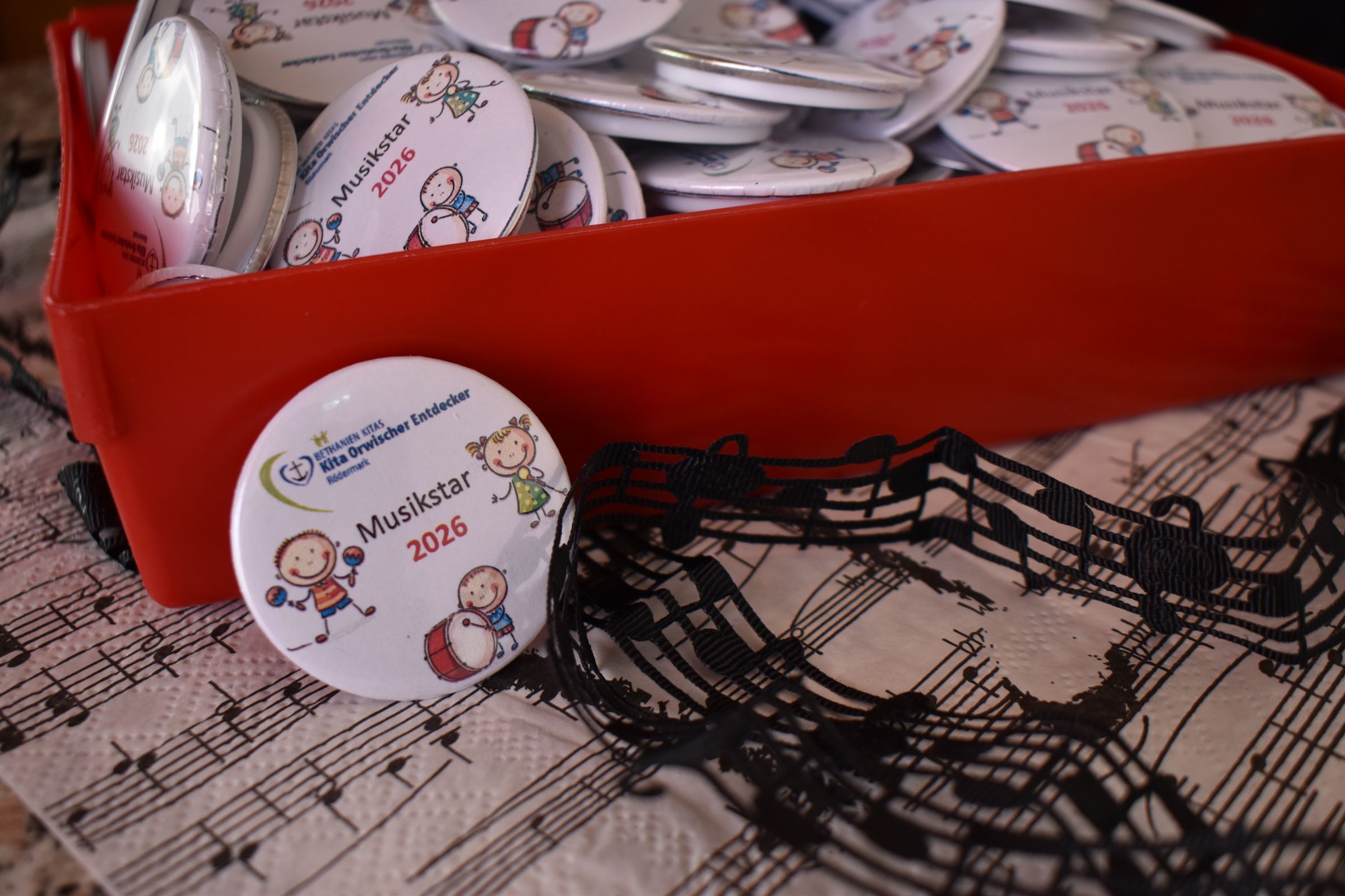 Buttons mit einer Musikstar Abbildung auf einem dekorierten Tisch