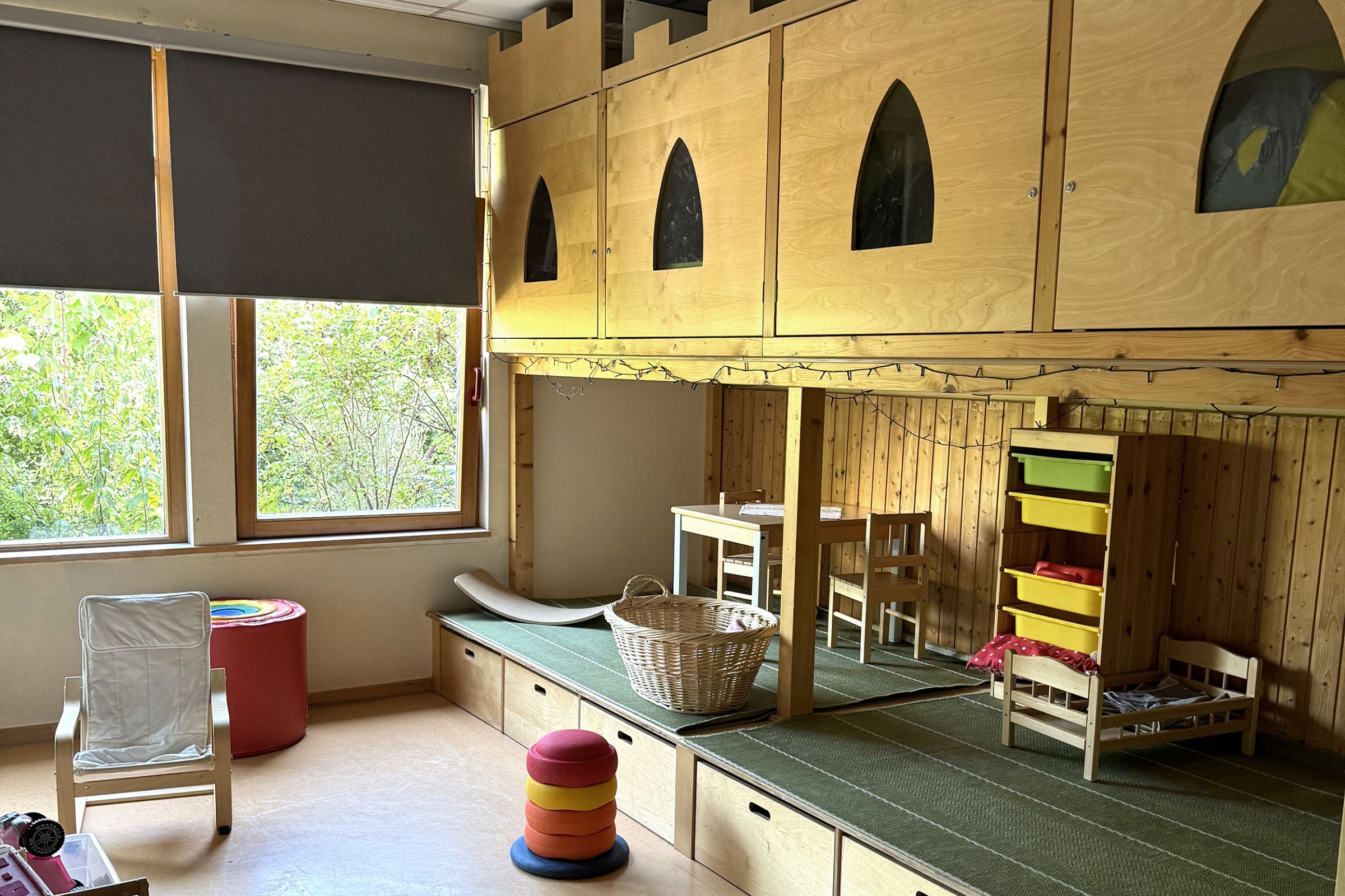 Ein Gruppenraum der Kita Arche Kunterbunt in Monheim mit Holzboden und im Stil einer Ritterburg