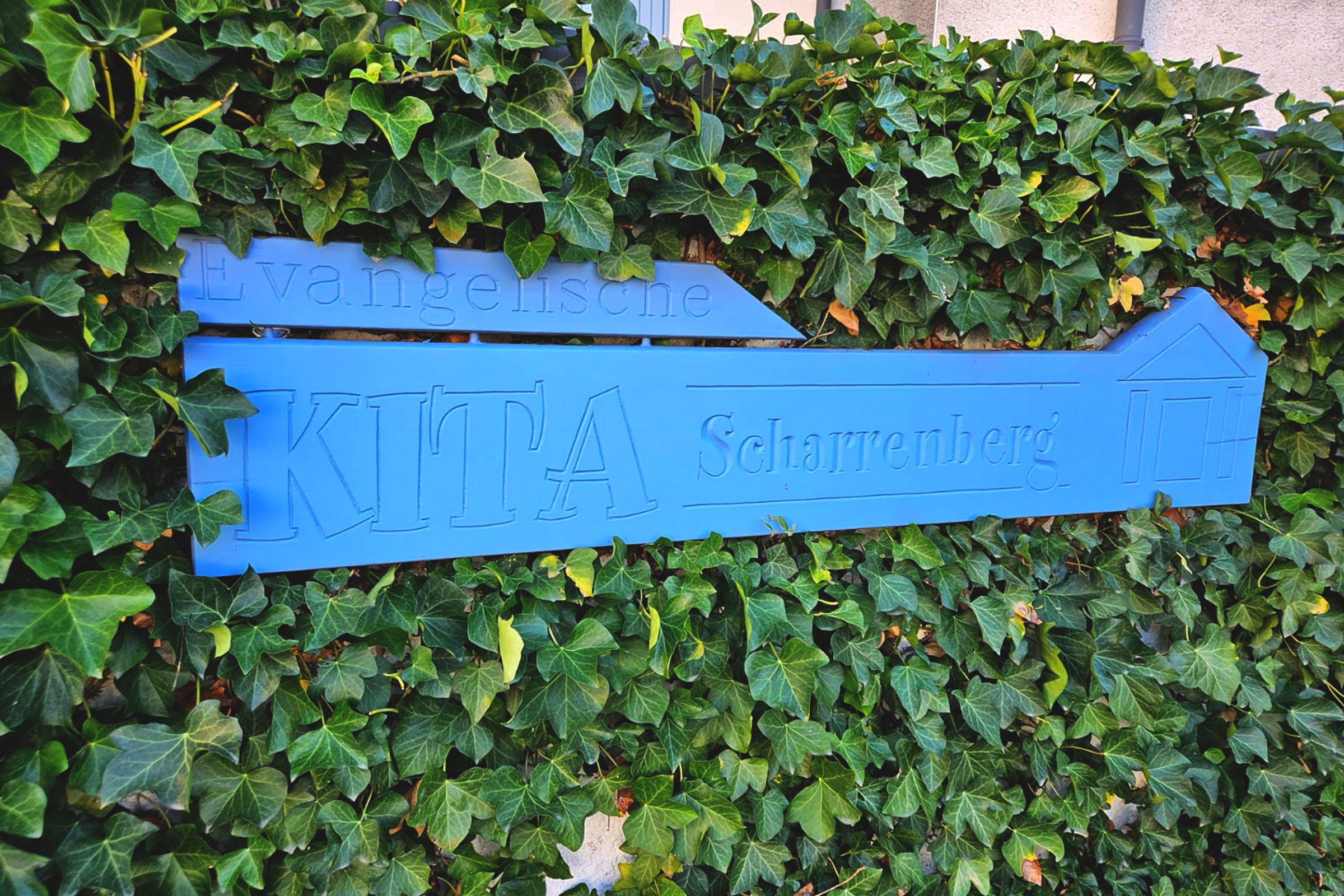 Das blaue Kita Schild vor der Ev. Kita Scharrenberger Straße