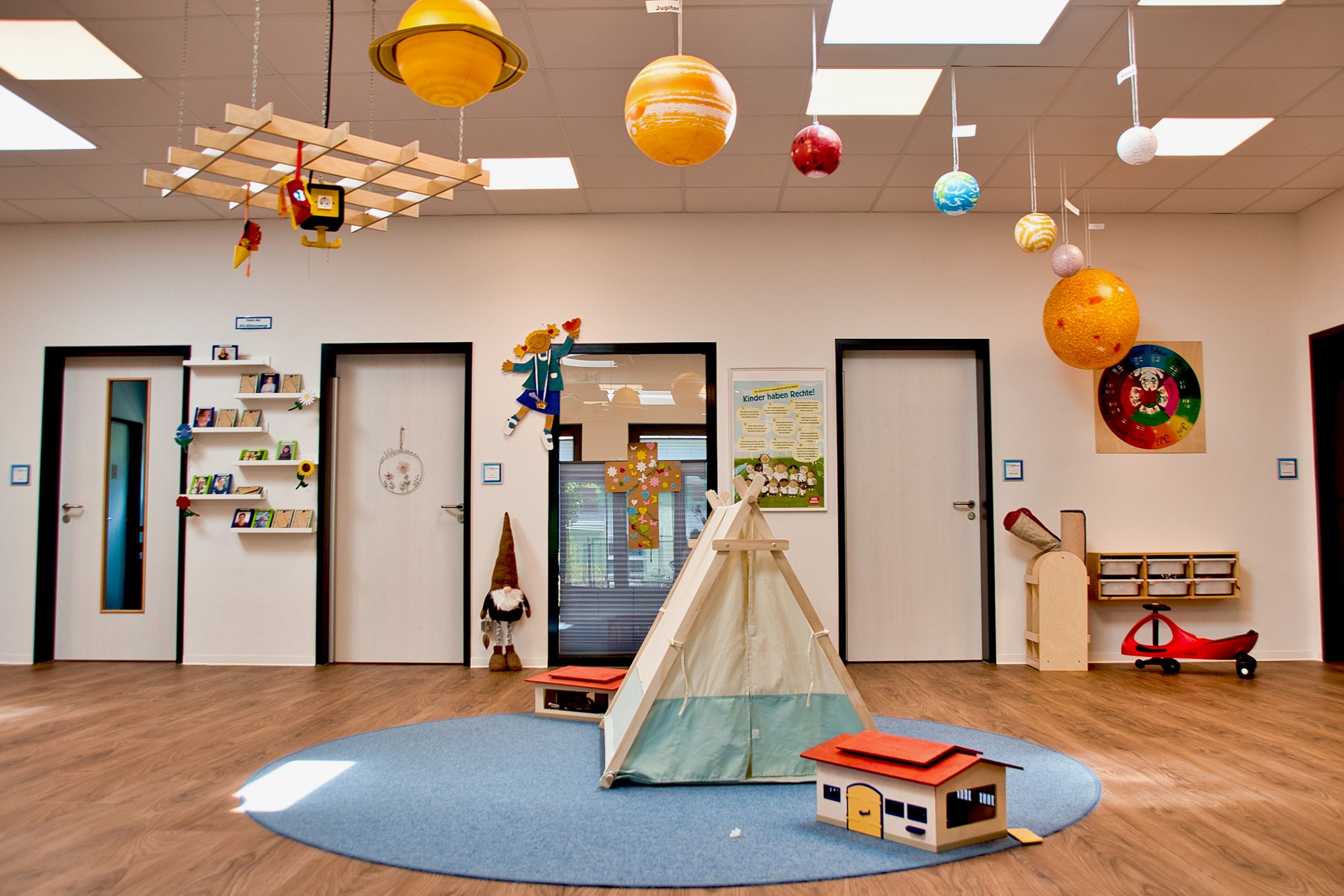 Ein Tipi Spielzelt über dem ein Sonnensystem hängt. 