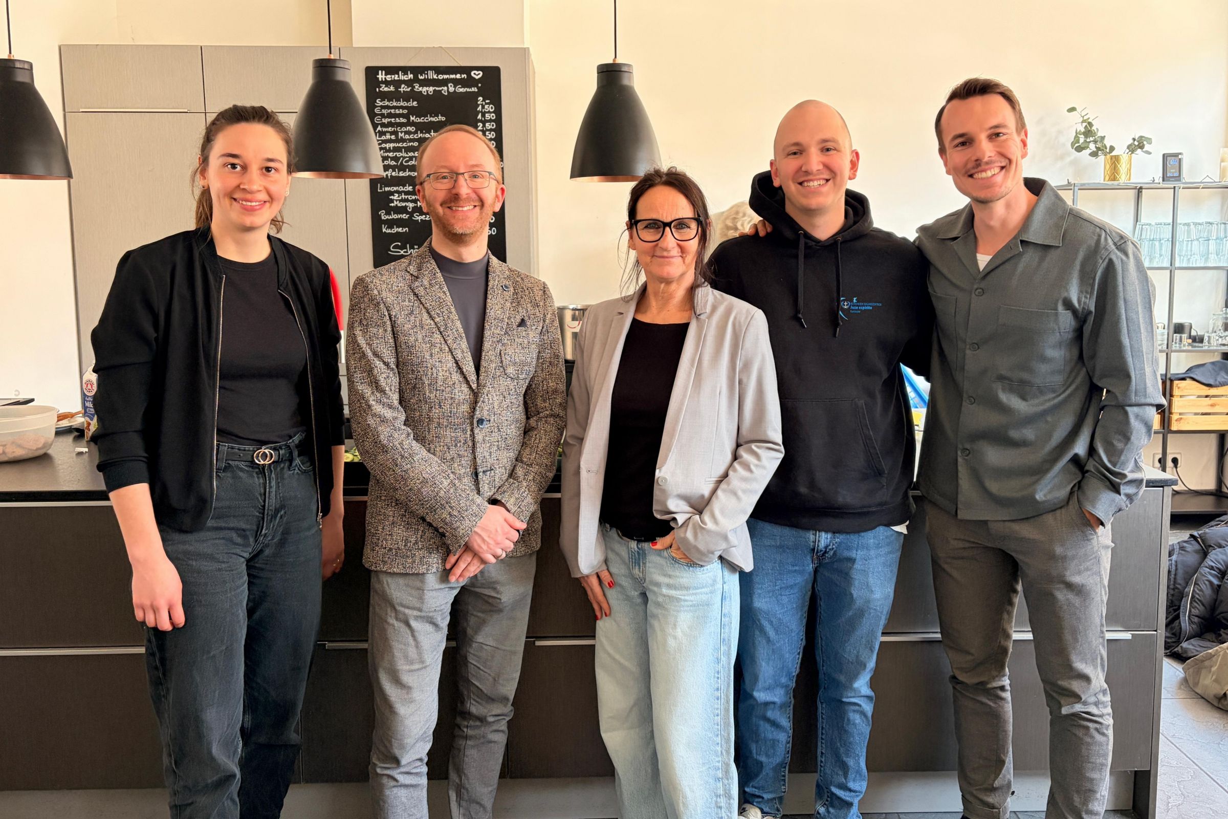 Fünf Personen in einer Reihe posieren für ein Foto