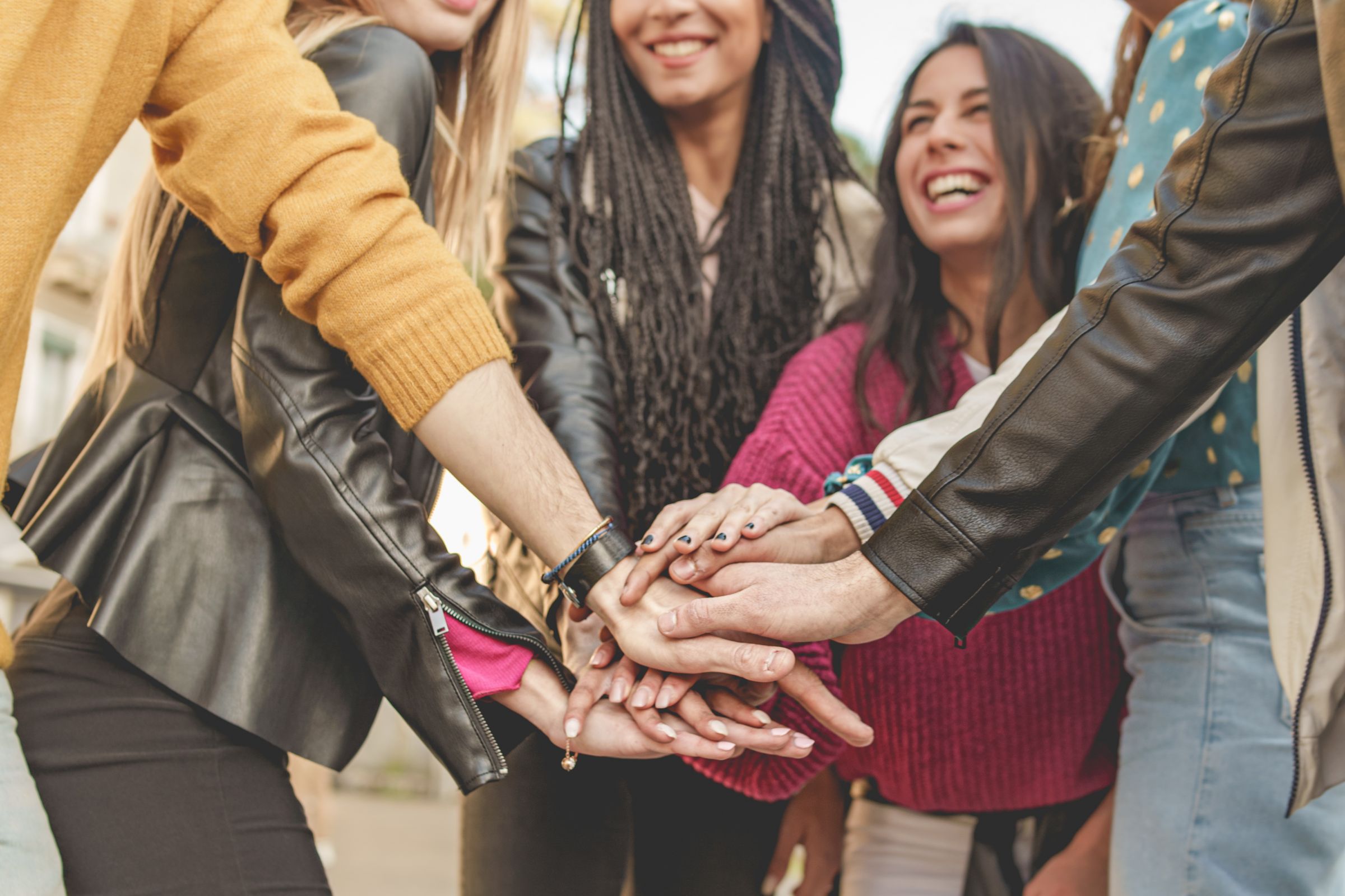 Menschen stehen in einem Kreis und halten ihre Hände zusammen