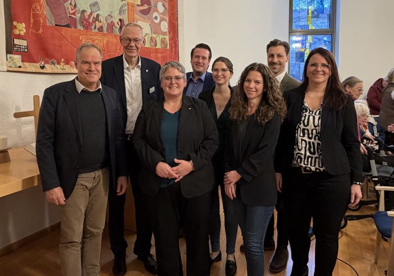 Ein Gruppenbild mit 8 Personen in einem hellen und modernen Altarraum