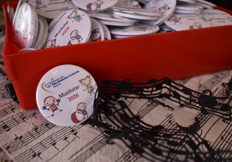 Buttons mit einer Musikstar Abbildung auf einem dekorierten Tisch