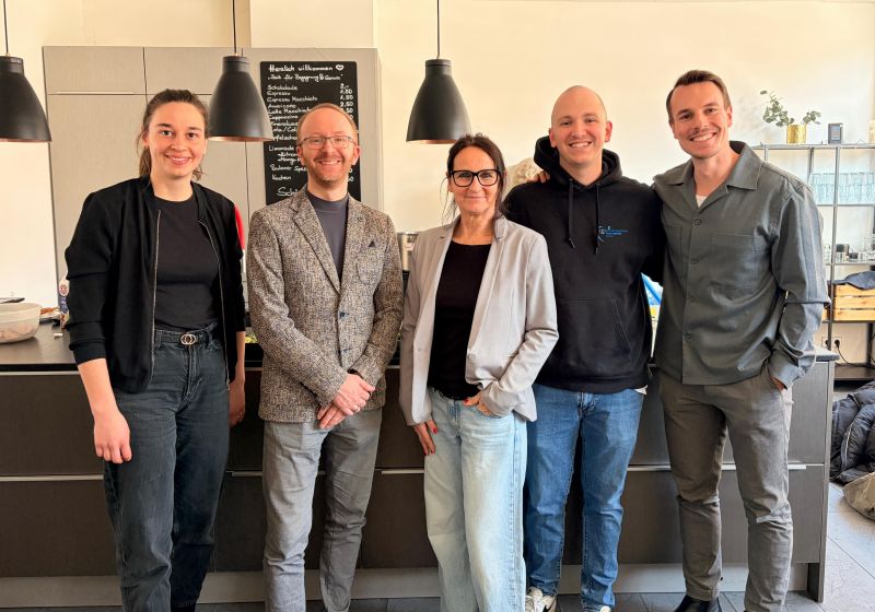 Fünf Personen in einer Reihe posieren für ein Foto