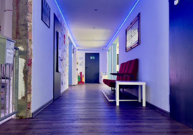 Flur des Jugendzentrums mit Sitzmöglichkeiten und blauen Deckenlichtern
